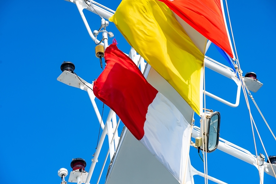 The yellow Q (Quarantine) Flag alongside red Pilot Flags.